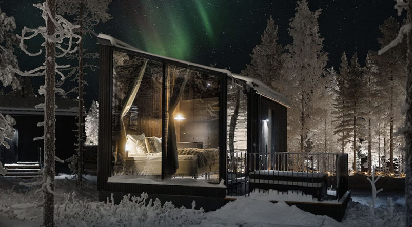 Glass-roof Arctic igloo at night with northern lights visible through the ceiling